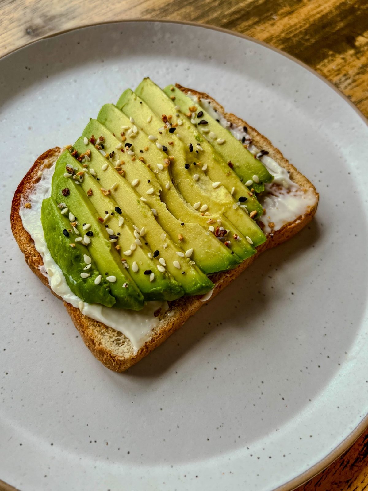 Avocado Toast on a white plate on a wooden table