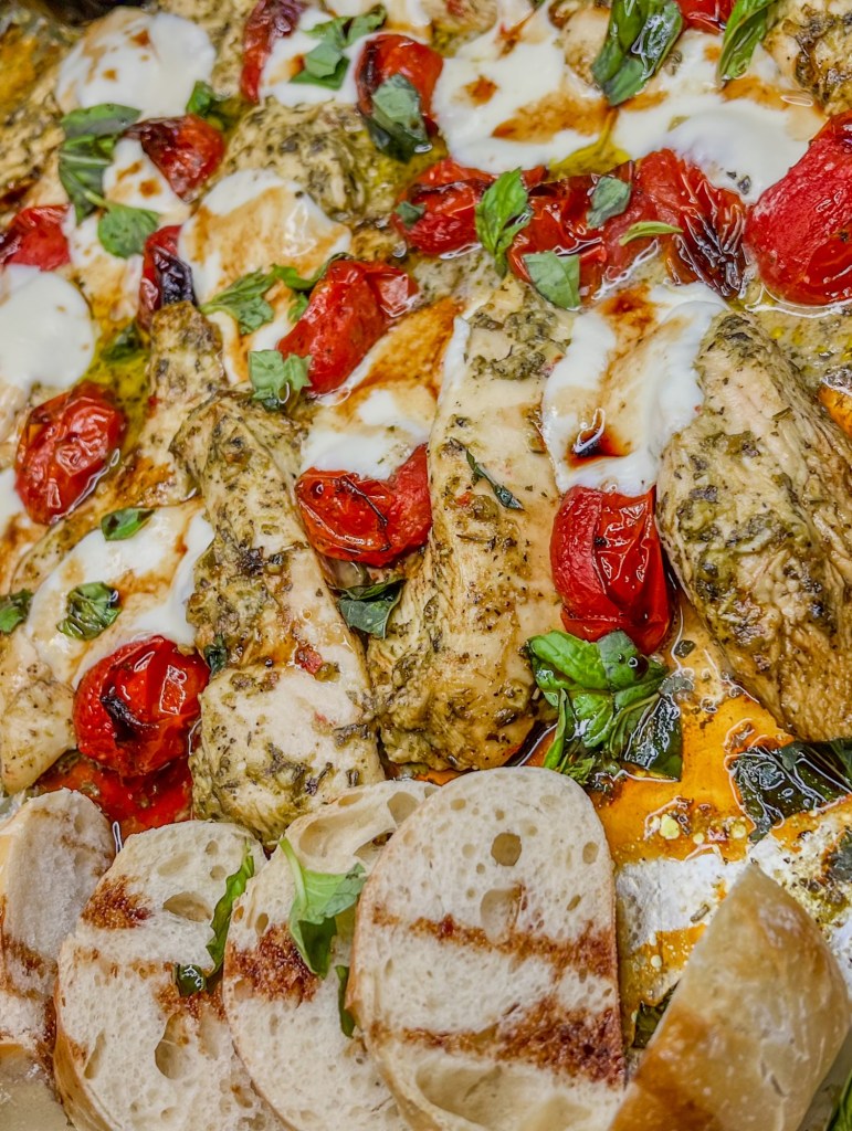 Caprese chicken sheet pan fresh out of the oven with balsamic glaze drizzled over the top