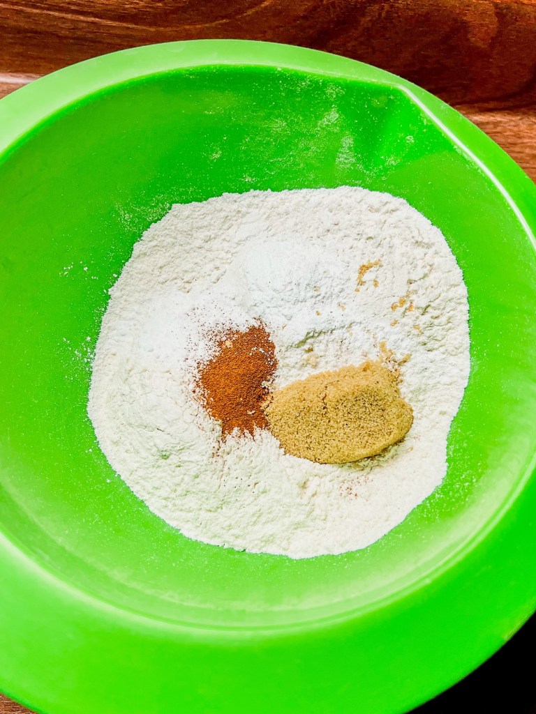 A green bowl filled with dry ingredients to make pancakes