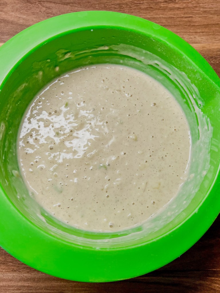 A green bowl filled with caramel apple pancake batter