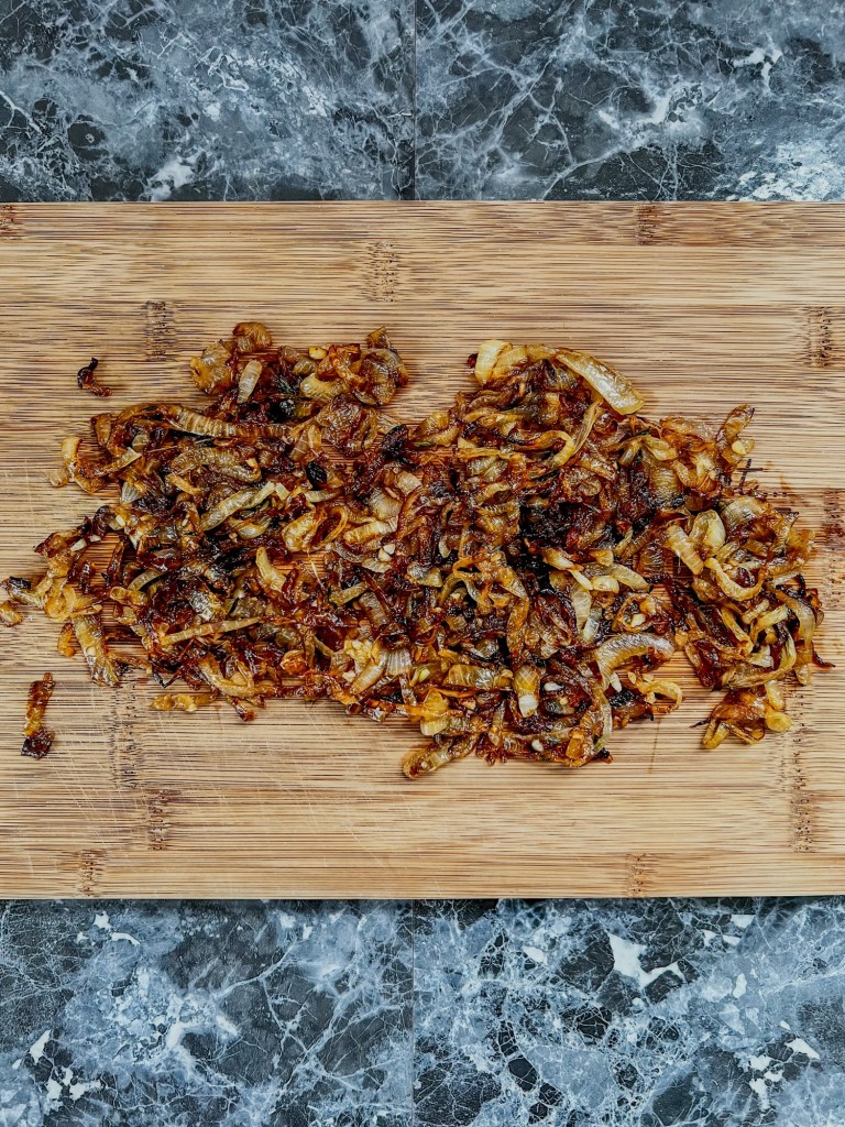 A bunch of caramelized onions on a cutting board