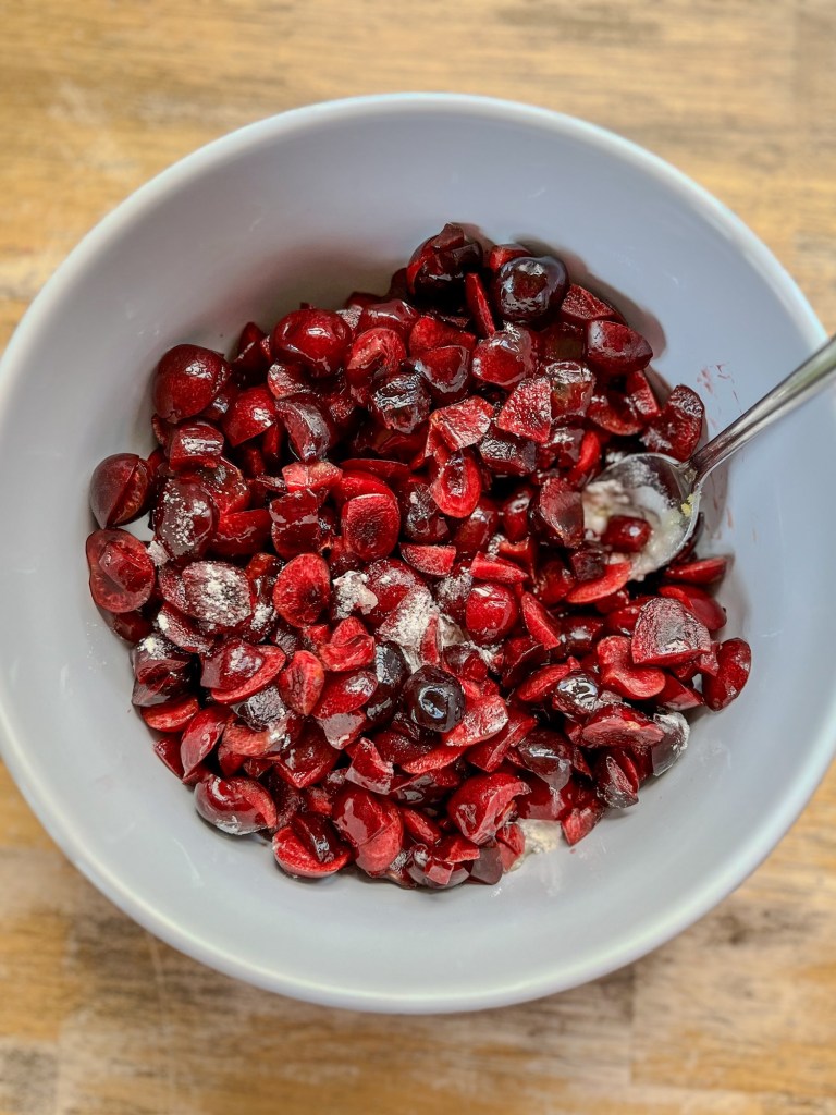 A big bowl filled with cherry cranberry cobbler filling before getting cooked on the stove