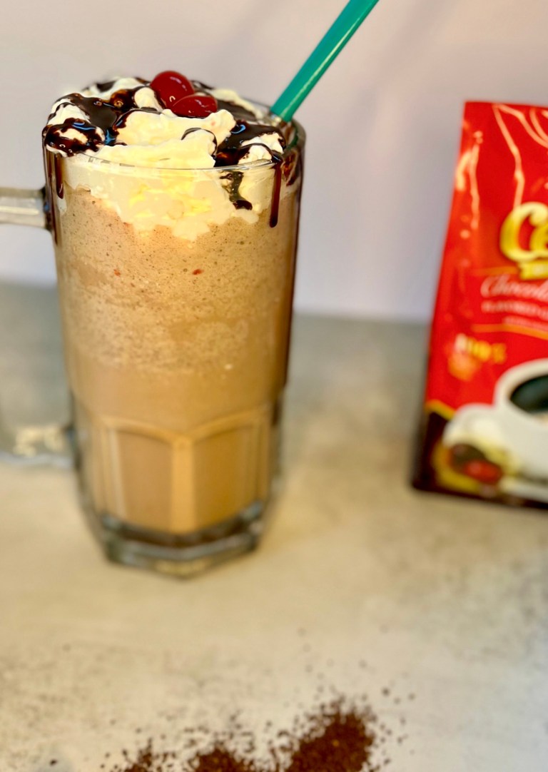 Chocolate Cherry Coffee Milkshake in a big mug with a bag of ground coffee next to it