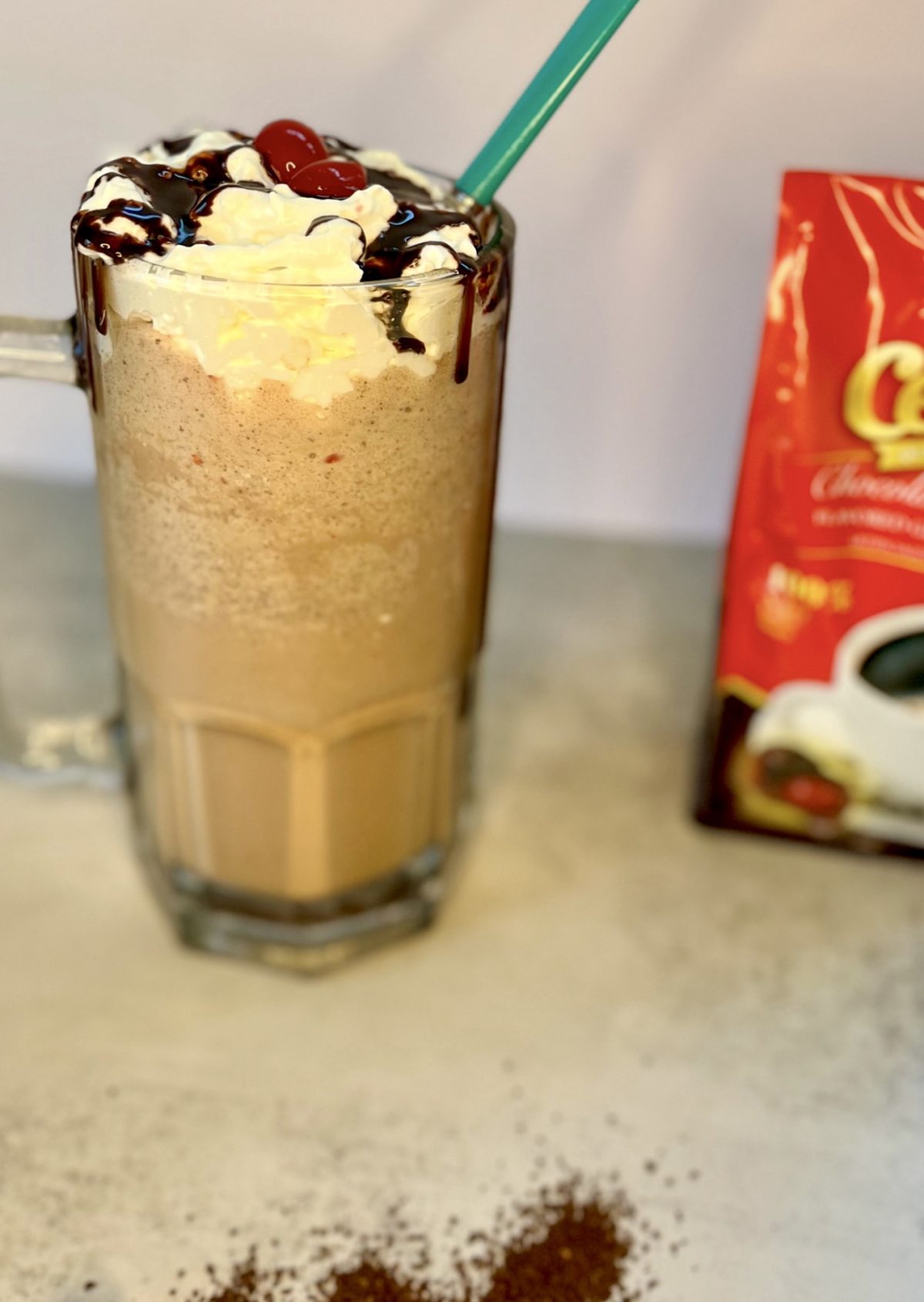 Chocolate Cherry Coffee Milkshake in a big mug with a bag of ground coffee next to it