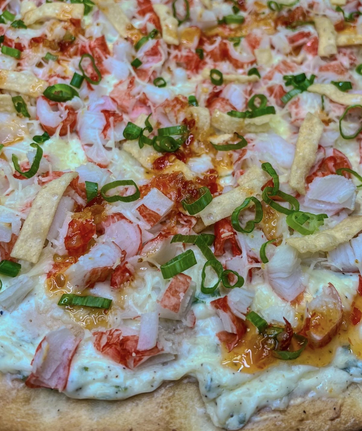 Crab Rangoon Pizza with green onion and sweet chili sauce on top