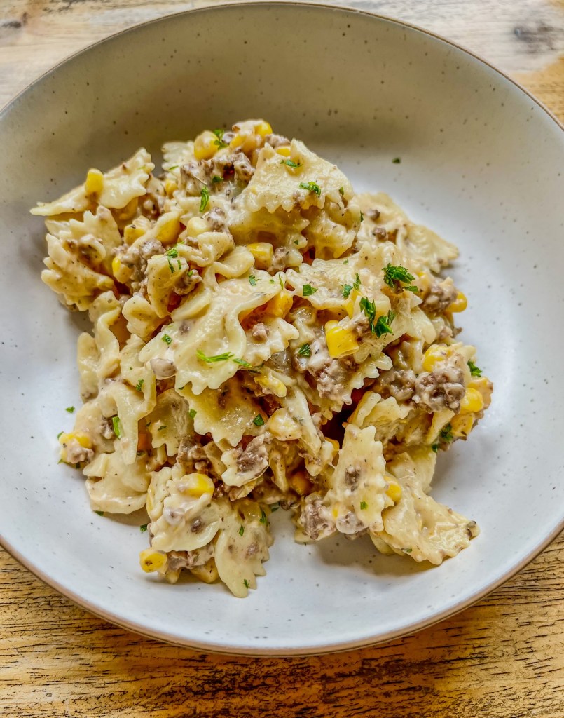 Creamy beef bowtie in a white bowl on a wooden table