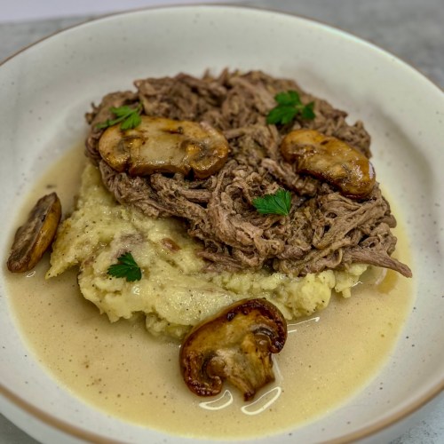 Crockpot tri-tip and mash in a white bowl on a countertop