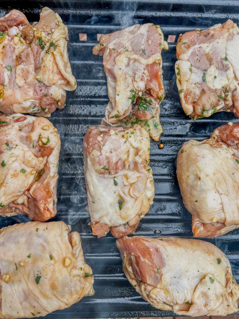 Chicken thighs that have been marinated in pineapple juice cooking on the grill
