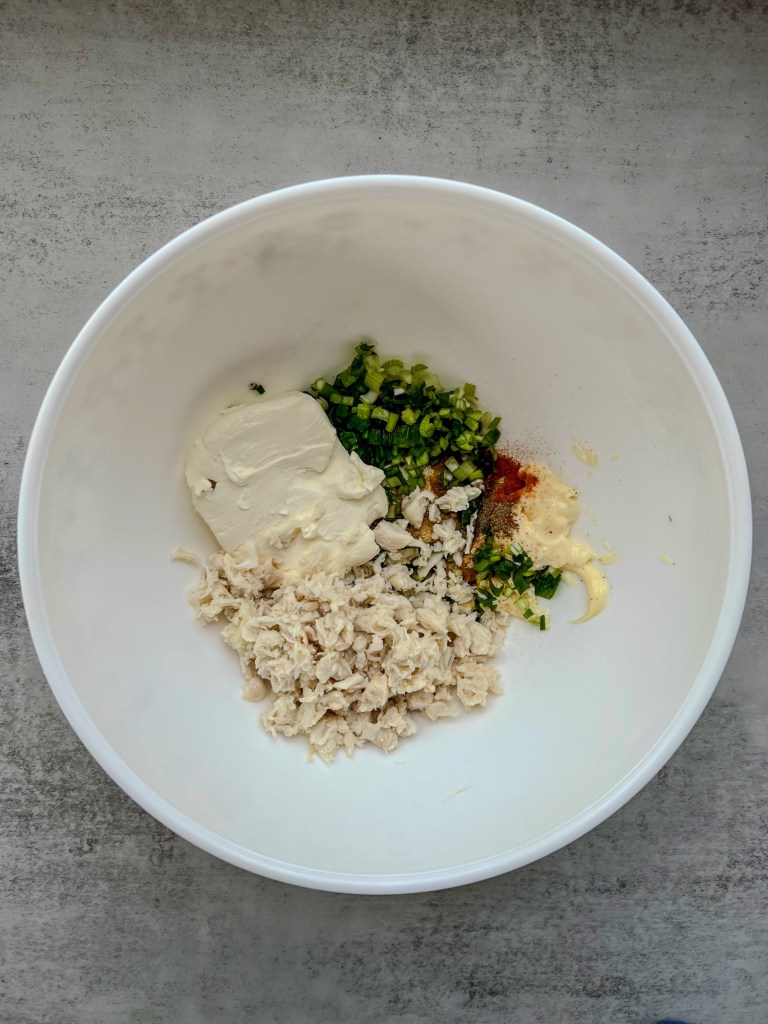 Filling for crab rangoons in a mixing bowl before being stirred