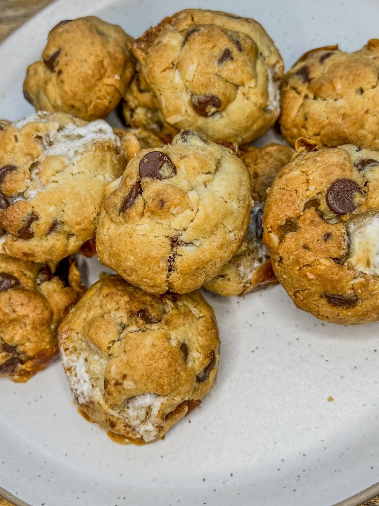 Chocolate Chip Coconut Marshmallow Cookies on a white plate on a wooden table