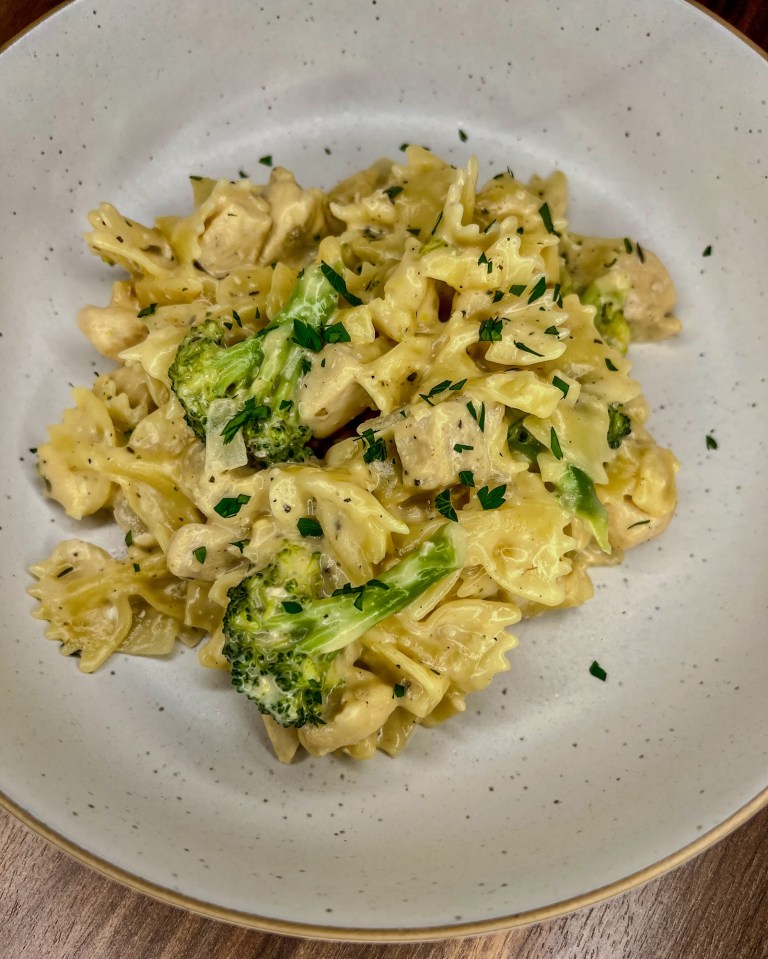 Cheddar Chicken Broccoli Bowtie in a white bowl on a wooden counter