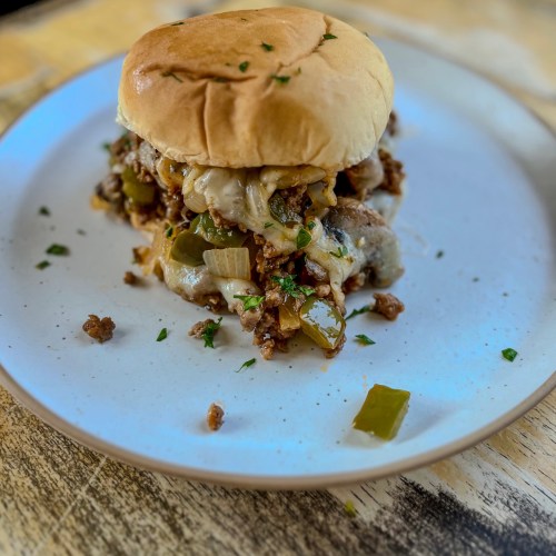 Mushroom Swiss Sloppy Joe on a bun on a white plate