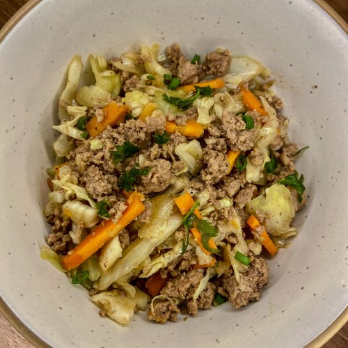 Egg roll bowl in a white bowl on a wooden counter
