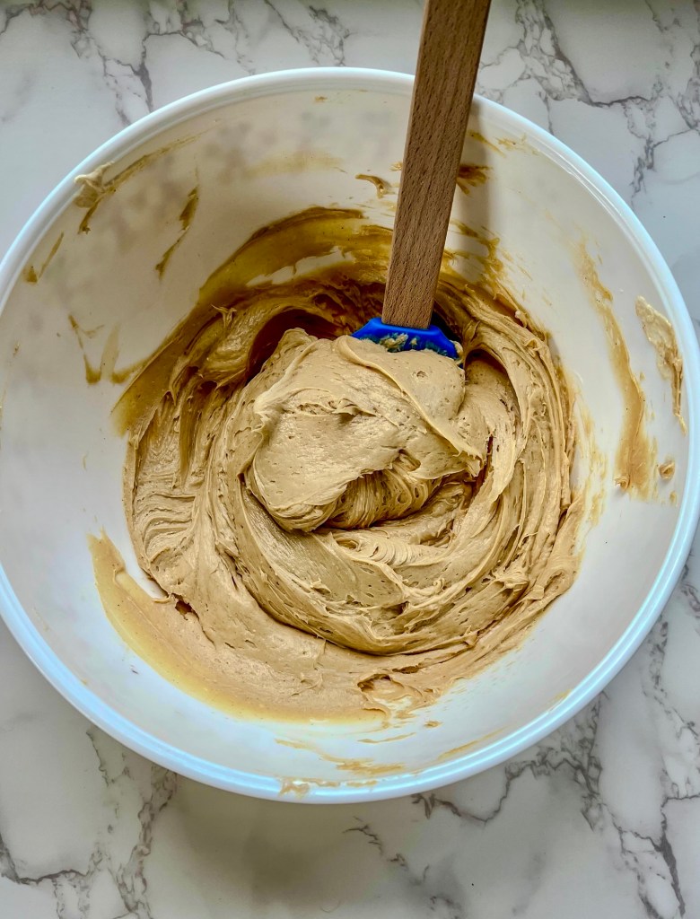 A large mixing bowl with peanut butter pie filling in it on a marble counter
