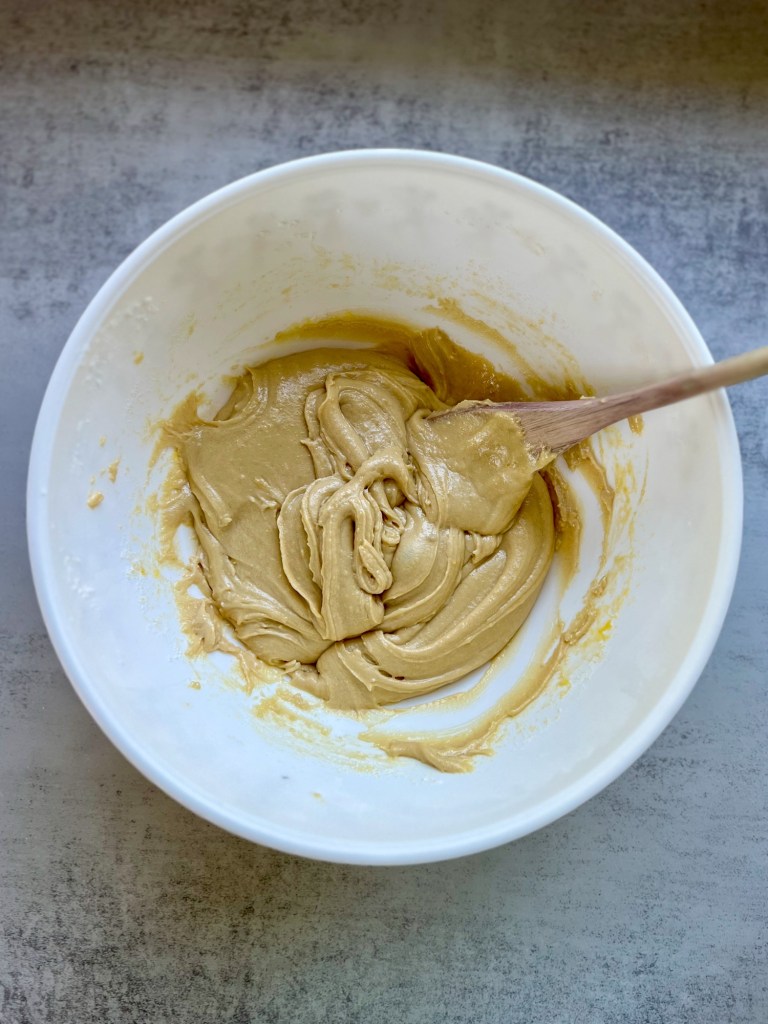 A large bowl filled with a batter to make pumpkin brownies