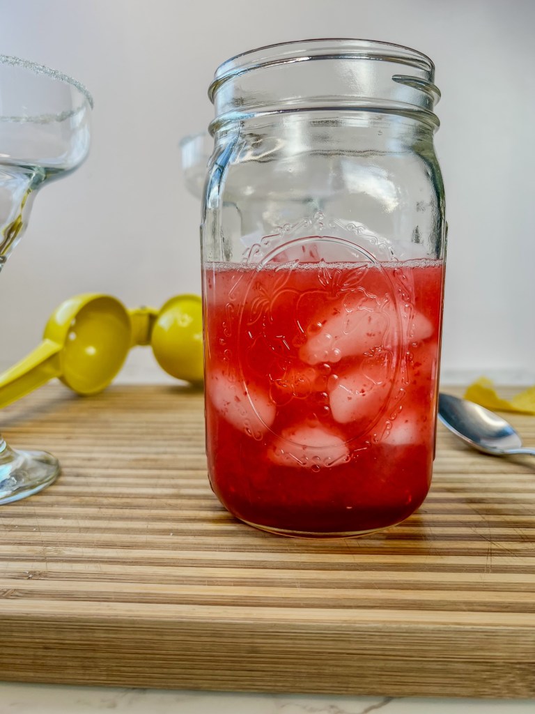Raspberry honey lemon daiquiri in a mason jar with some ice