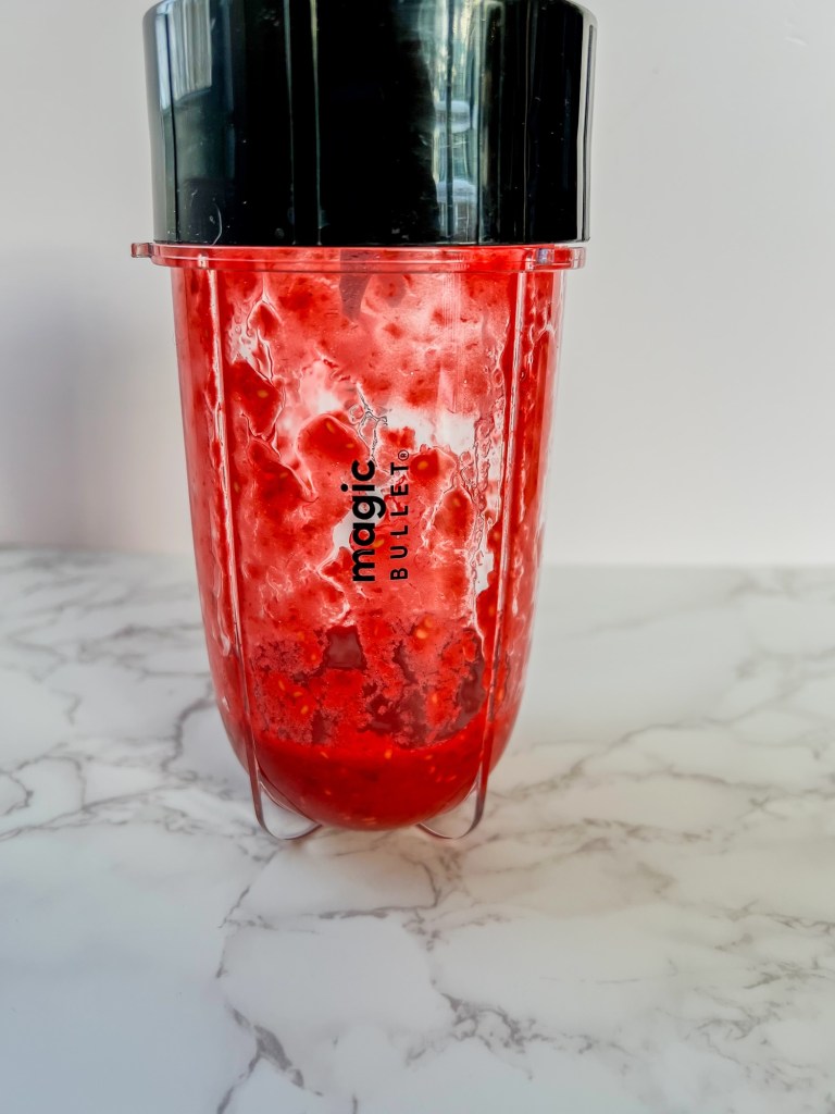 Raspberry and water after being blended into a puree
