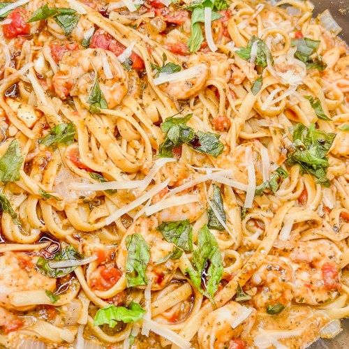Shrimp pesto pasta in a large skillet on the stove