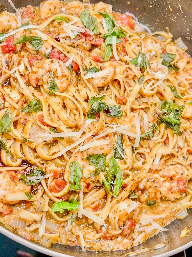 Shrimp pesto pasta in a large skillet on the stove