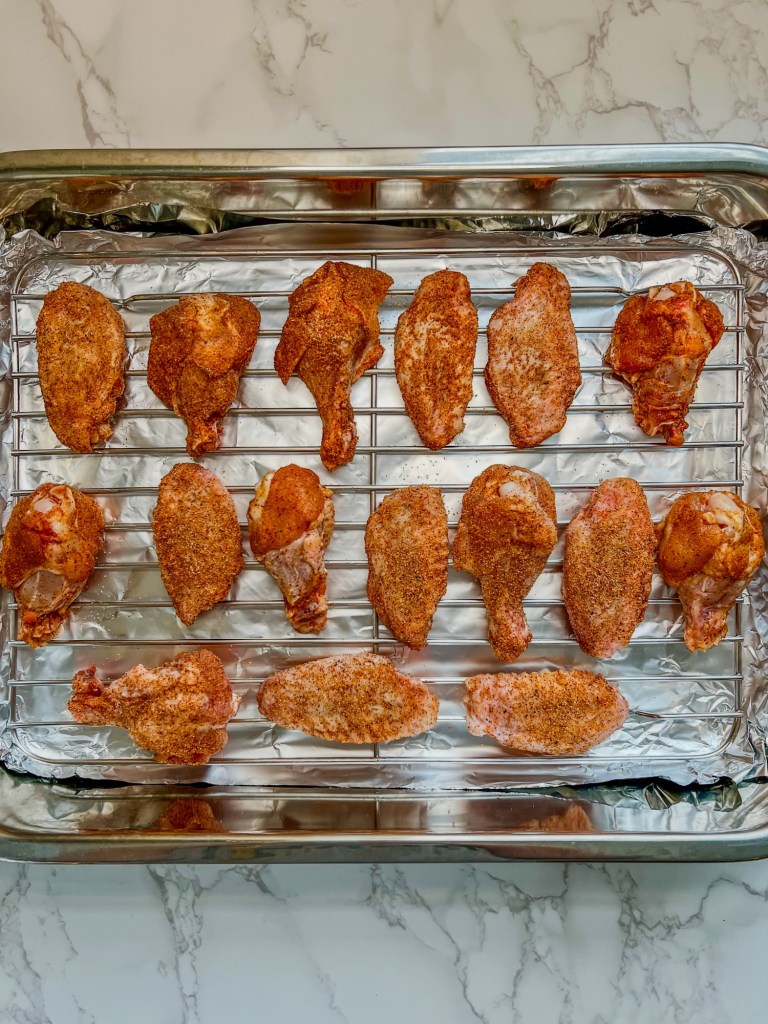 Chicken wings that have been tossed in spices, getting ready to be baked