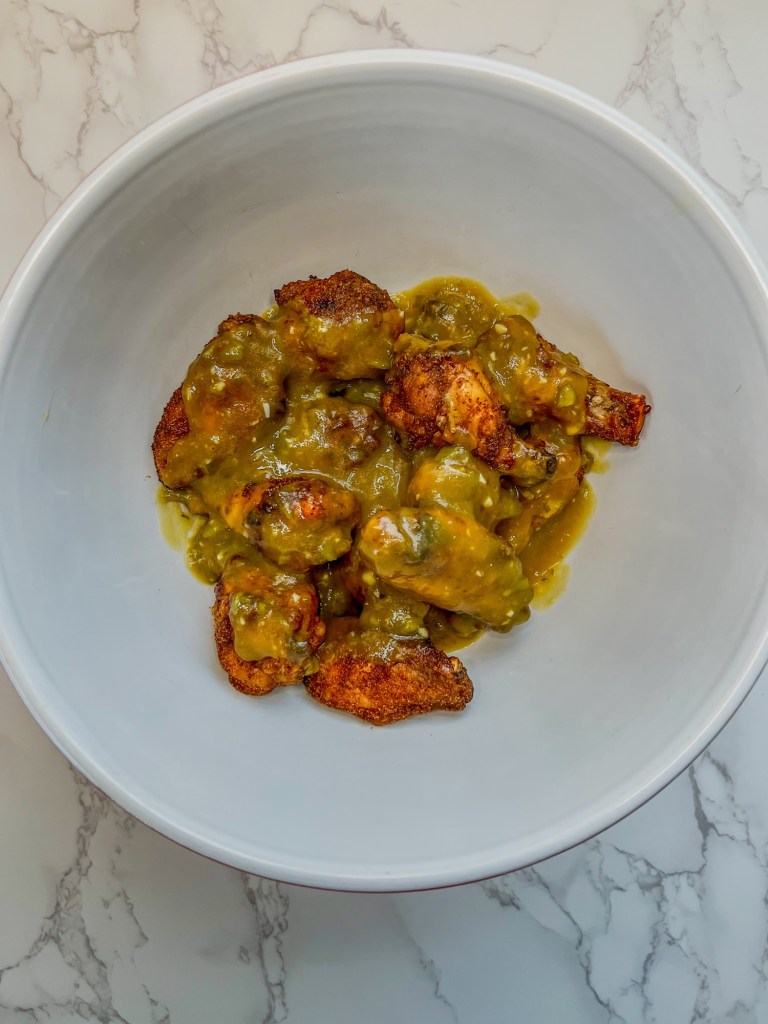 Chicken wings in a bowl with some mango serrano lime sauce