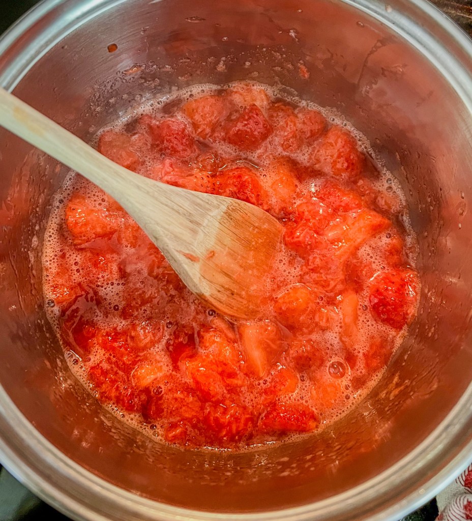 Smushed strawberries in a saucepan on the stove