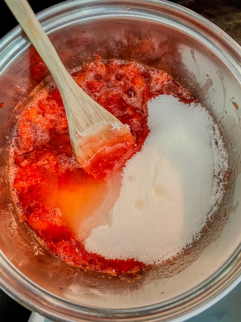 Strawberries in a saucepan with lemon juice and sugar on the stove