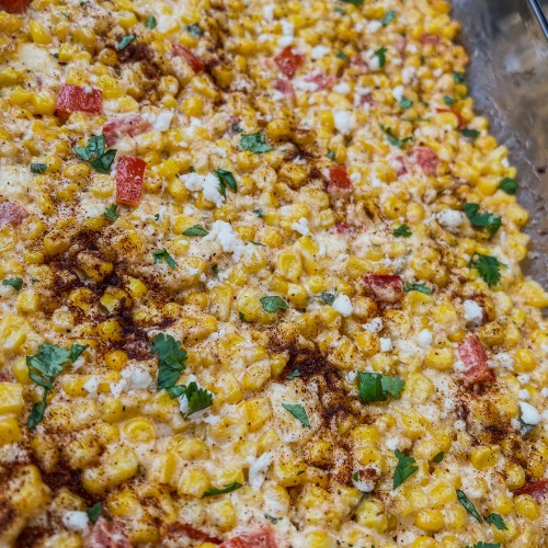 Street corn casserole in a baking dish on a wooden table