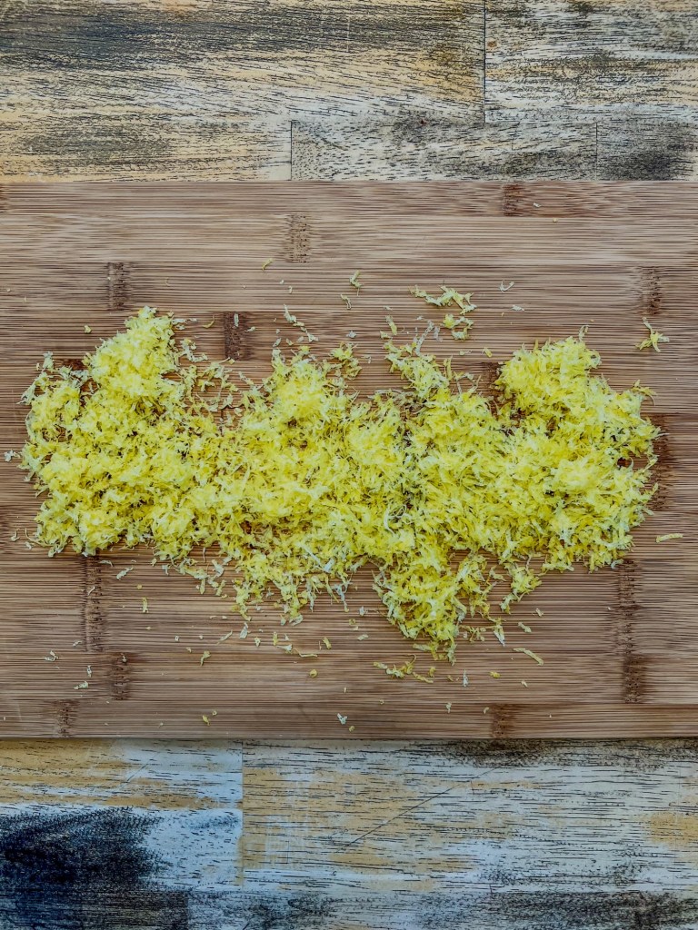 A bunch of lemon zest on a wooden cutting board