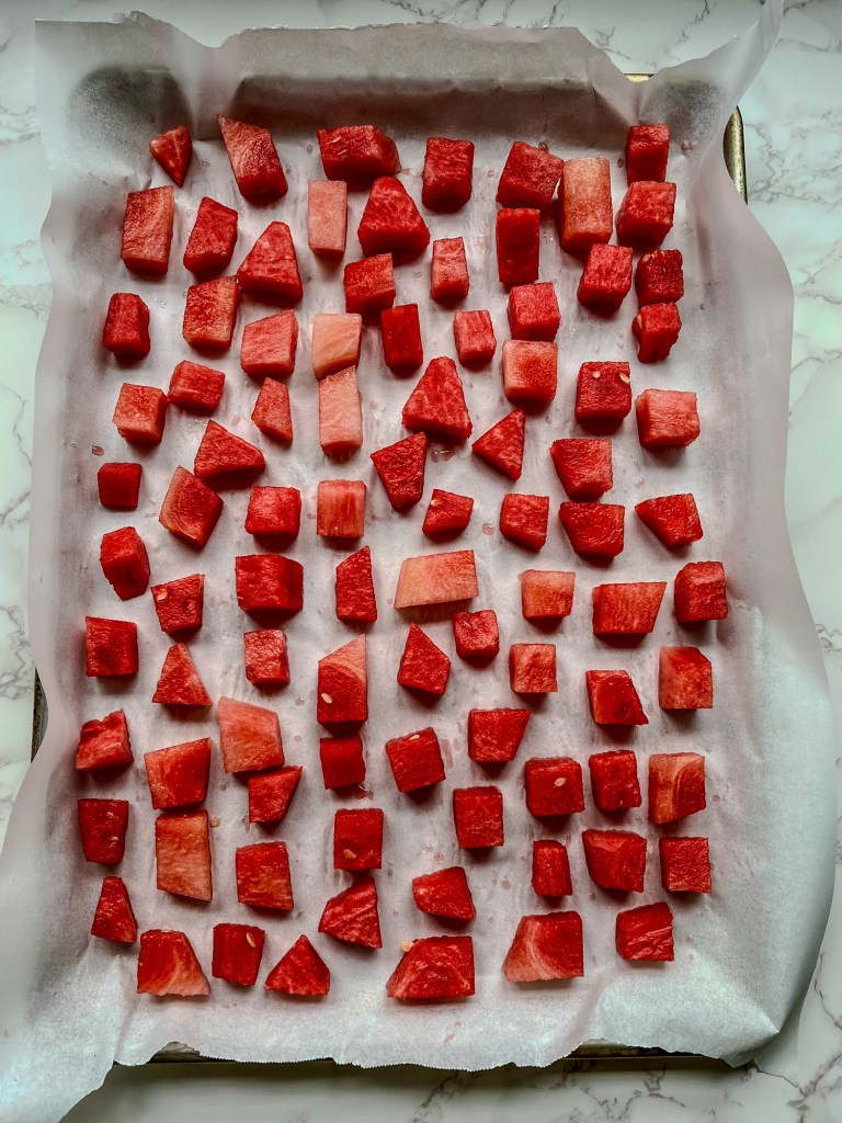 Watermelon chunks on a baking sheet with parchment paper