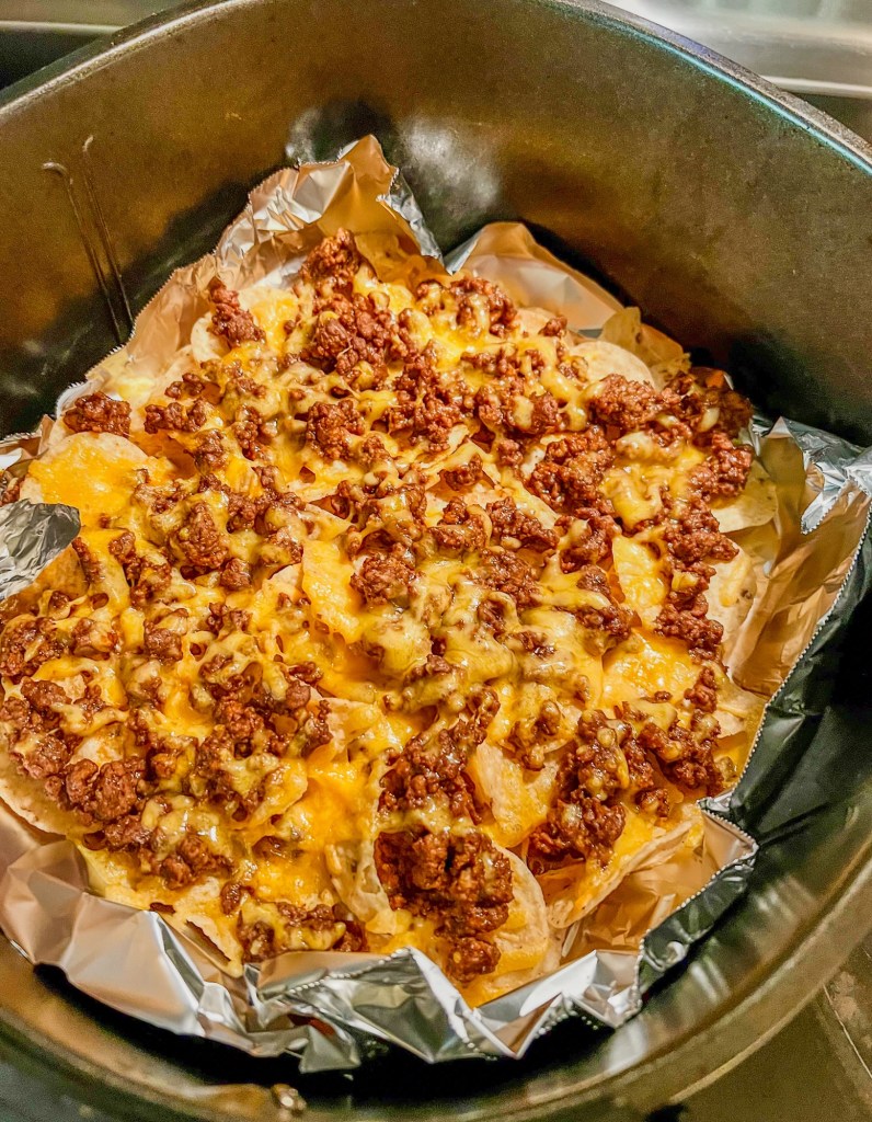 Air fryer nachos in an air fryer basket before any garnishes are put on