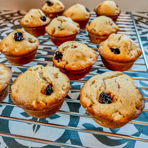 Apple cherry muffins on a cooling rack on a countertop