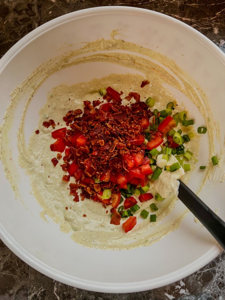 Ingredients for avocado blt dip in a mixing bowl before being mixed up
