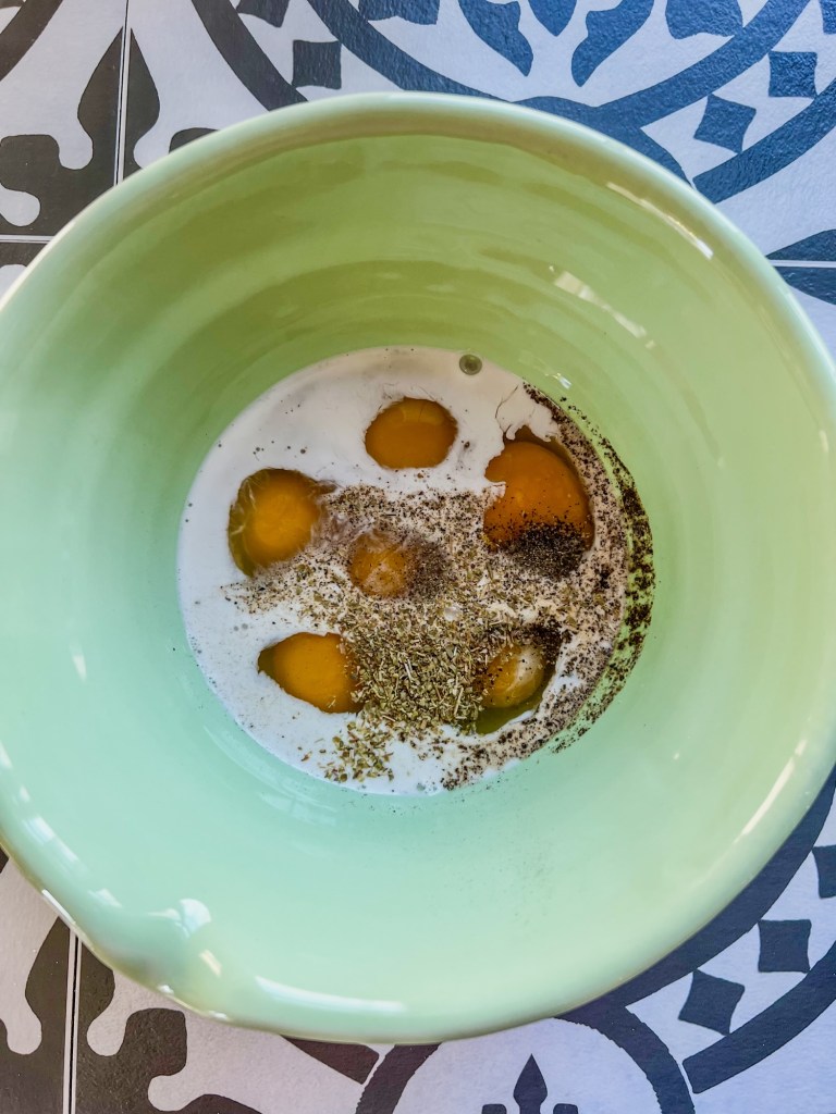 Eggs and spices in a bowl before being whisked