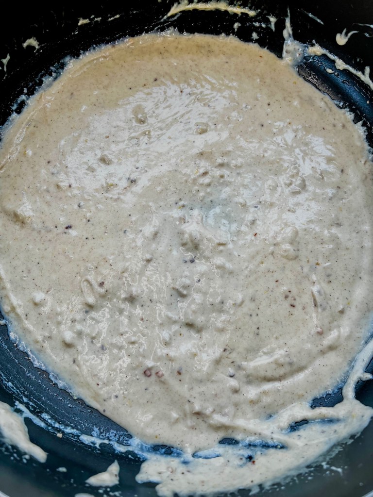 Brown butter alfredo sauce in a skillet with freshly added lemon juice, zest, freshly cracked black pepper, and crushed red pepper