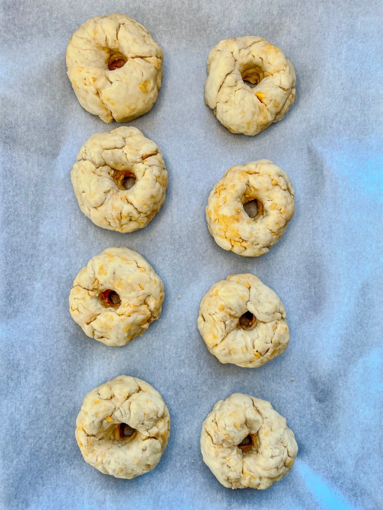 Cheddar bagels on a baking sheet with parchment paper just before getting kettle-boiled