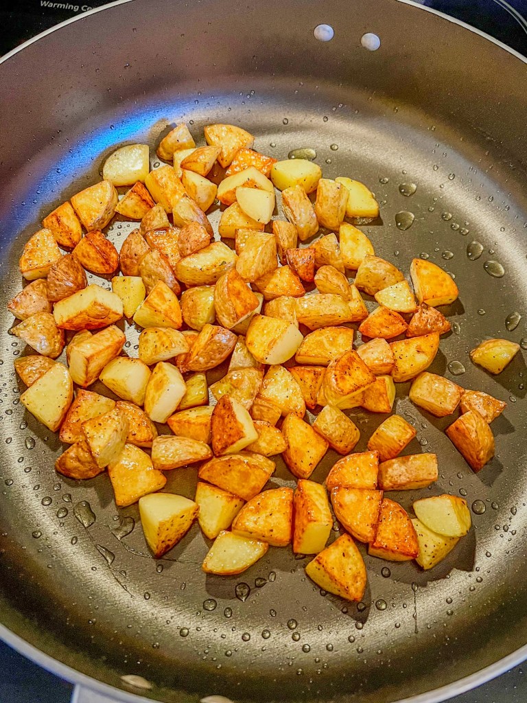 Diced yellow potatoes cooking in a skillet