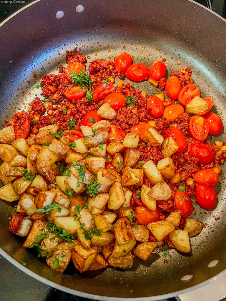 Ingredients for chorizo hash cooking in a skillet