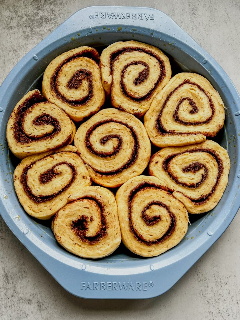 Cinnamon rolls in a blue pan before being baked