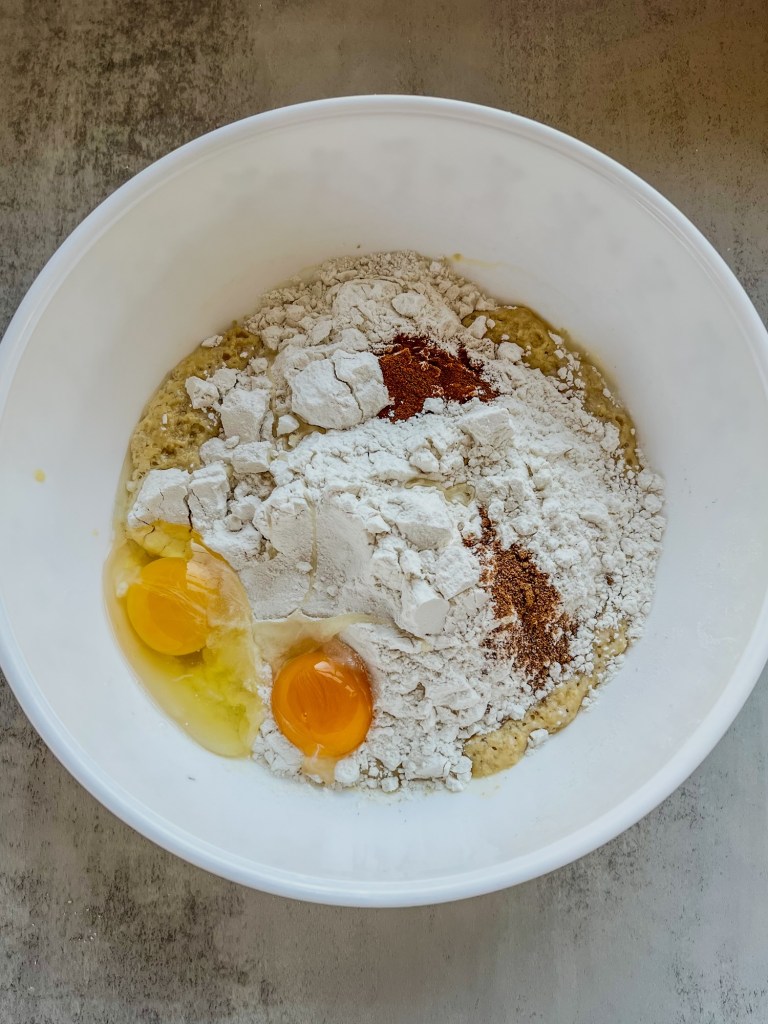 Eggnog cinnamon roll dough ingredients in a large mixing bowl