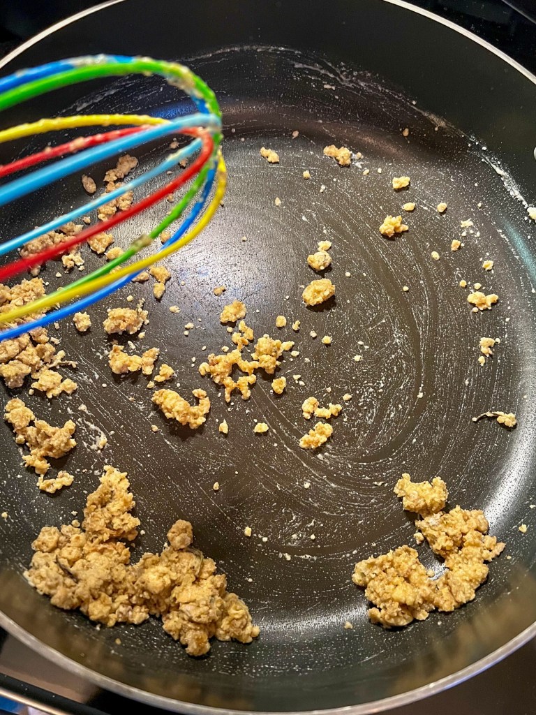 Turkey fat and flour cooking in a skillet while being whisked constantly