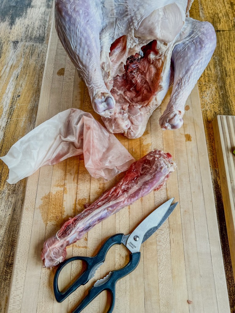 Turkey on a cutting board after the neck, giblets, and heart have been removed