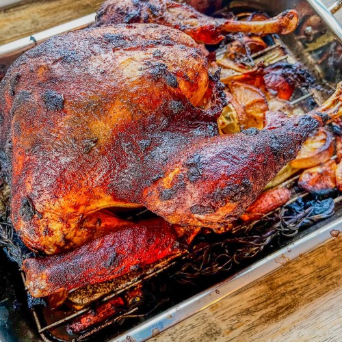 Garlic herb roasted turkey in a pan on a wooden table