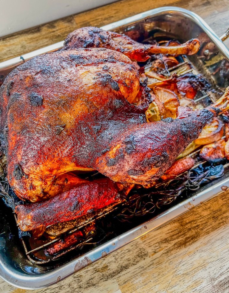 Garlic herb roasted turkey in a pan on a wooden table