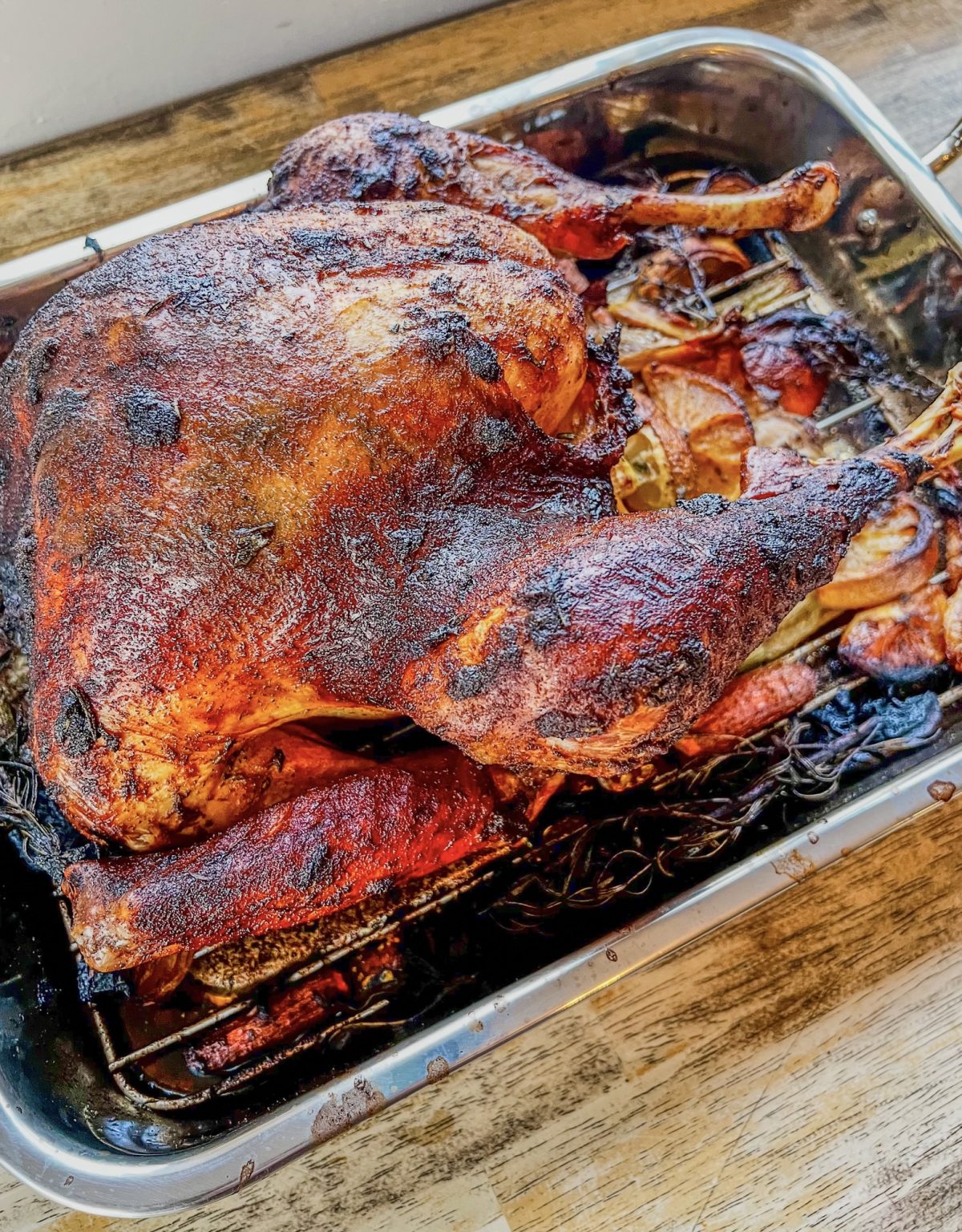 Garlic herb roasted turkey in a pan on a wooden table
