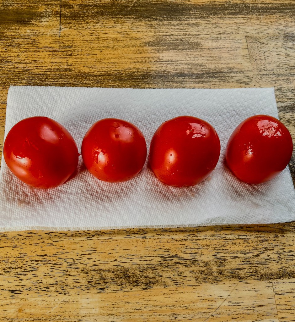 Hollowed out tomatoes upside down on a paper towel to drain