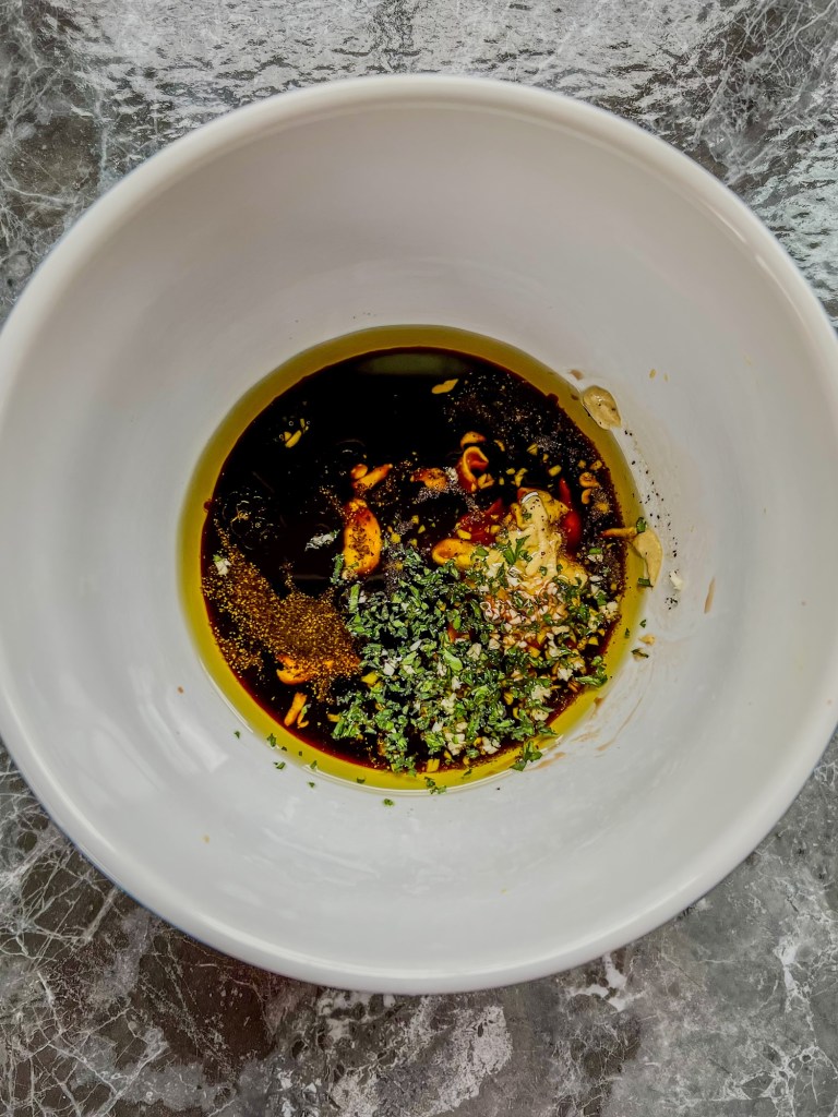 Ingredients for honey balsamic vinaigrette in a large mixing bowl before being whisked