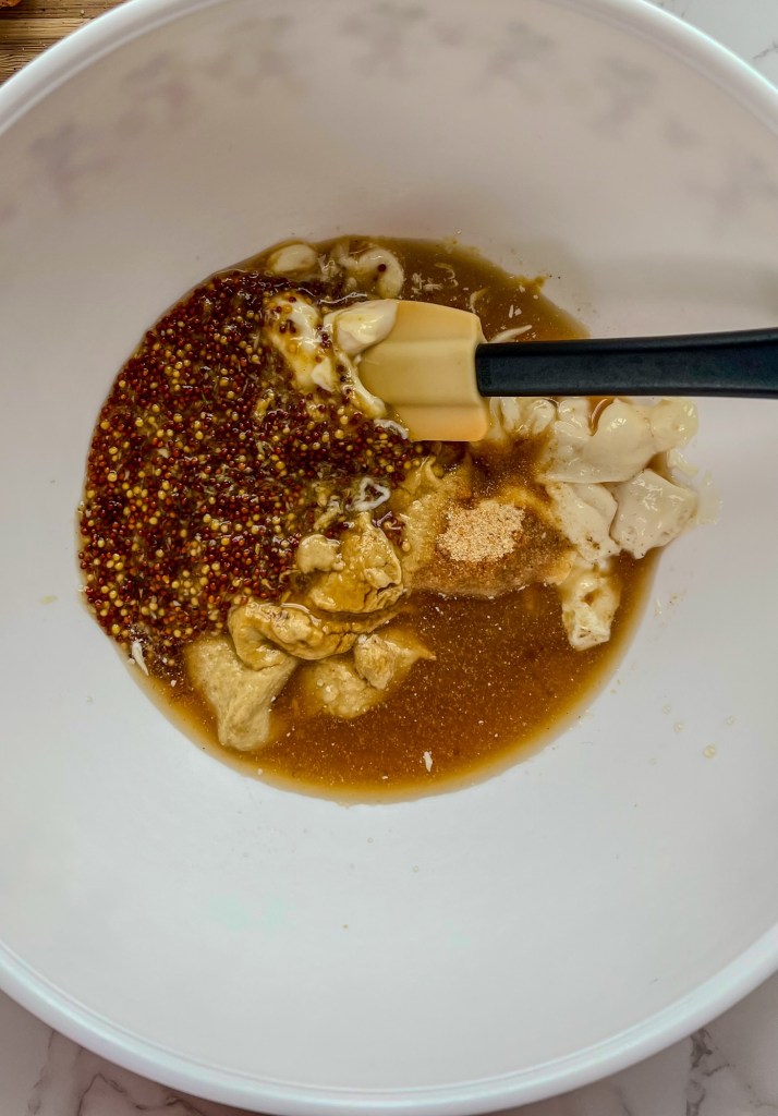 Honey mustard sauce in a mixing bowl before being mixed to combine