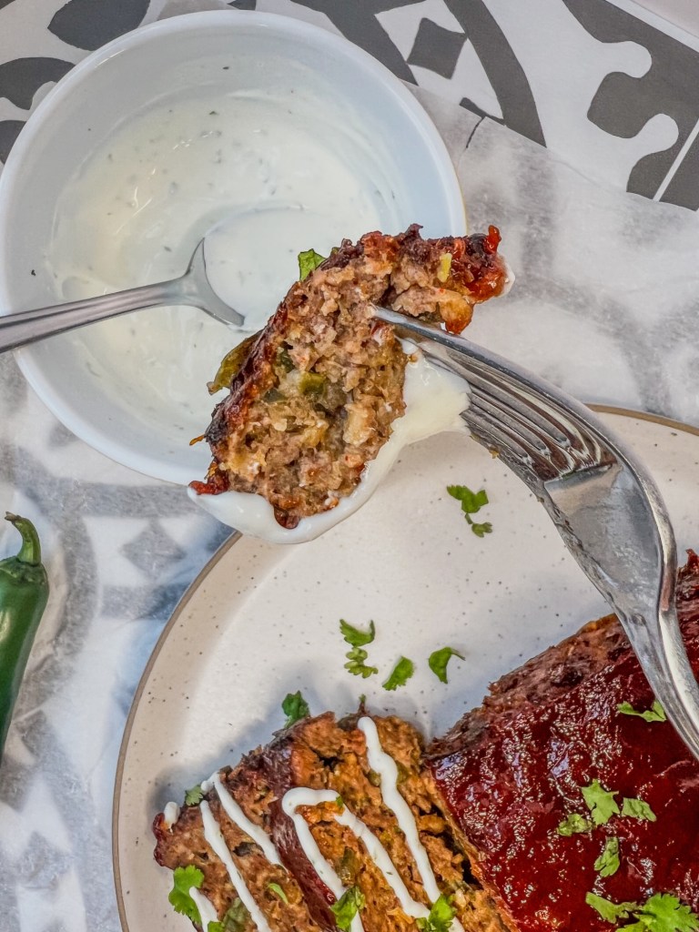 Jalapeno Cheddar Meatloaf sliced and served with a limey sour cream