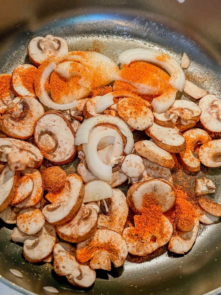 Mushroom, onion, butter, and steak seasoning in a large skillet on the stove